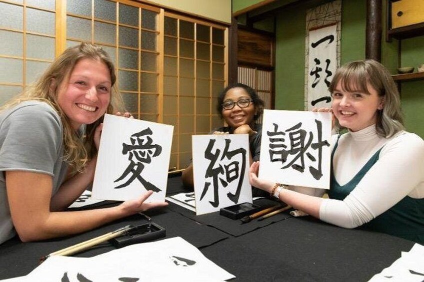 Three people holding calligraphy characters. 4