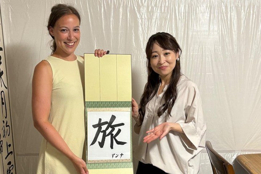Two people holding a large box with Japanese characters. 1