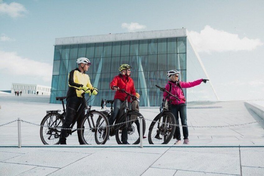 Drei Radfahrer vor einem modernen Glasgebäude. 3