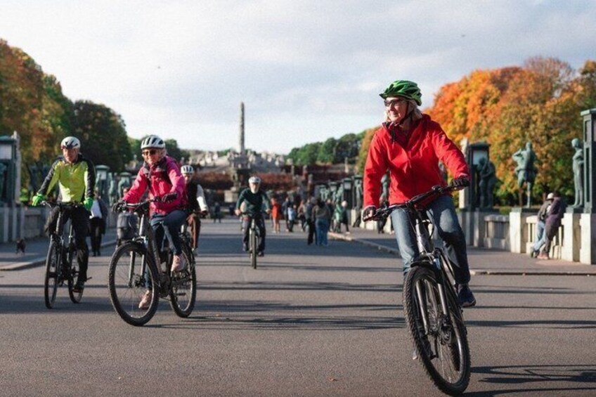 Radfahrer auf einer Brücke, im Hintergrund Herbstlaub. 4