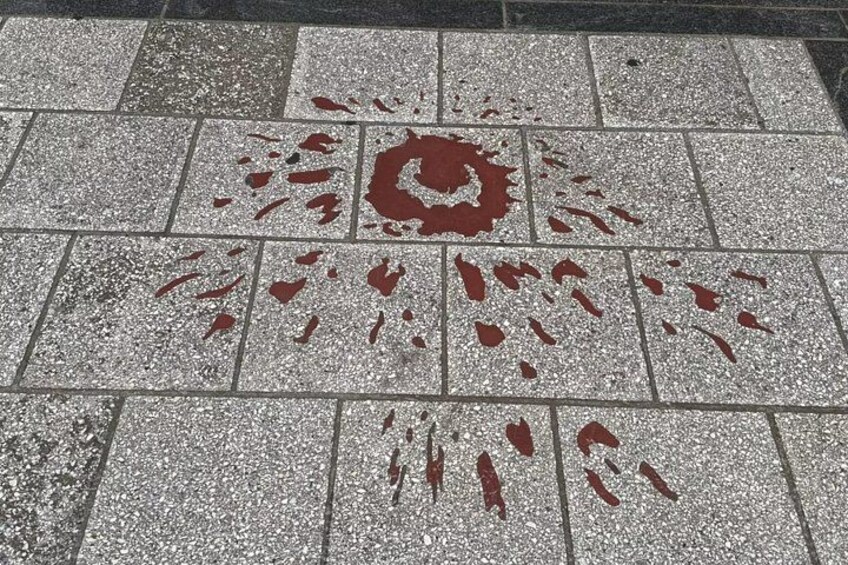 A tiled floor with a pattern of red stains. 2