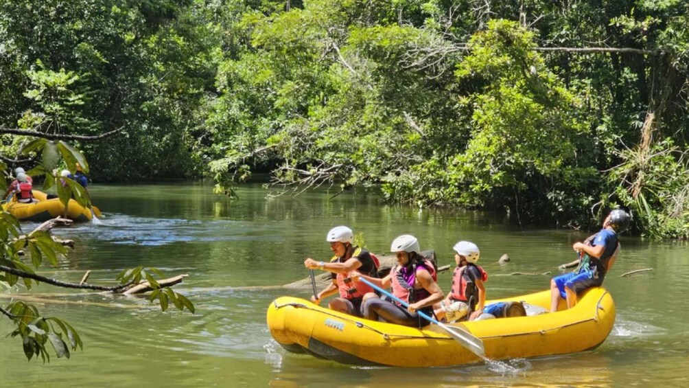 People rafting on a river surrounded by dense greenery. 1