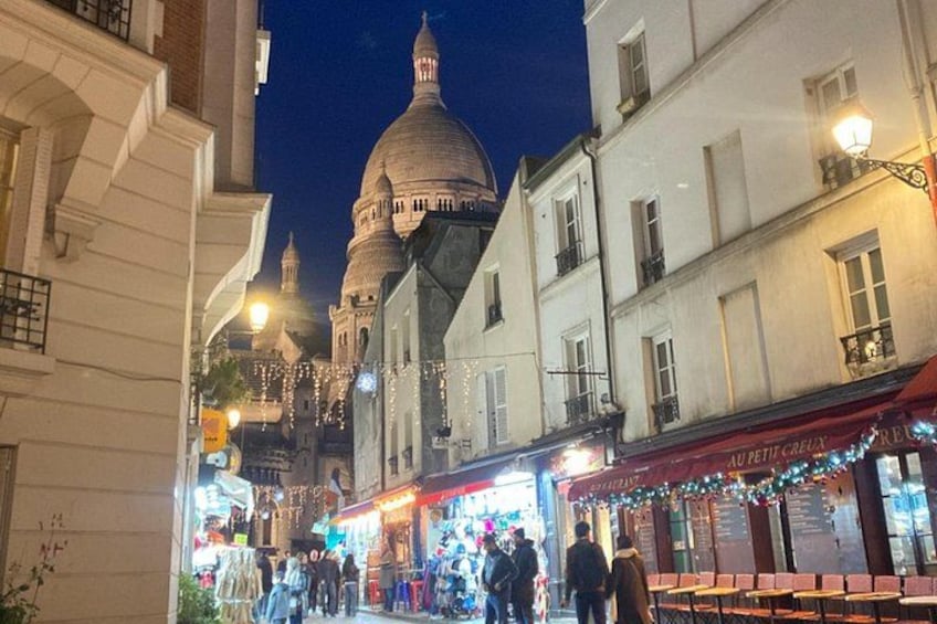 Une rue bordée de boutiques, avec un grand bâtiment en forme de dôme en arrière-plan. 5