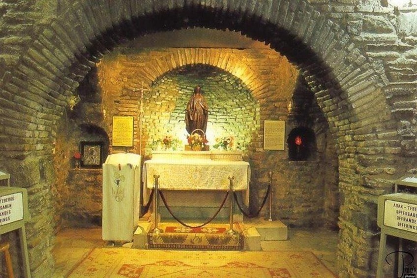 A stone-arched room with a statue, a table with a cloth, and a sign. 4
