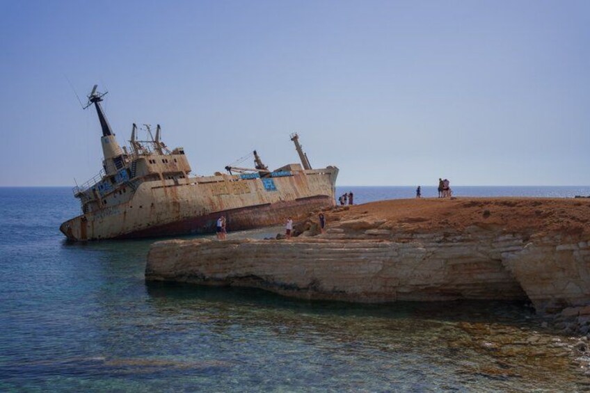 Een gezonken schip aan een rotsachtige kust met helder water. 5