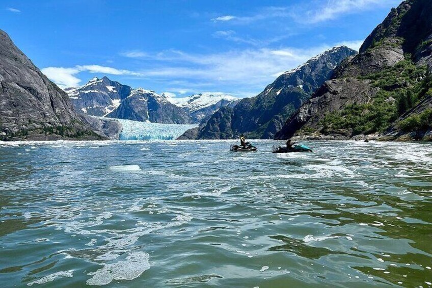 Un ghiacciaio in una valle montana con due kayak sull'acqua. 1