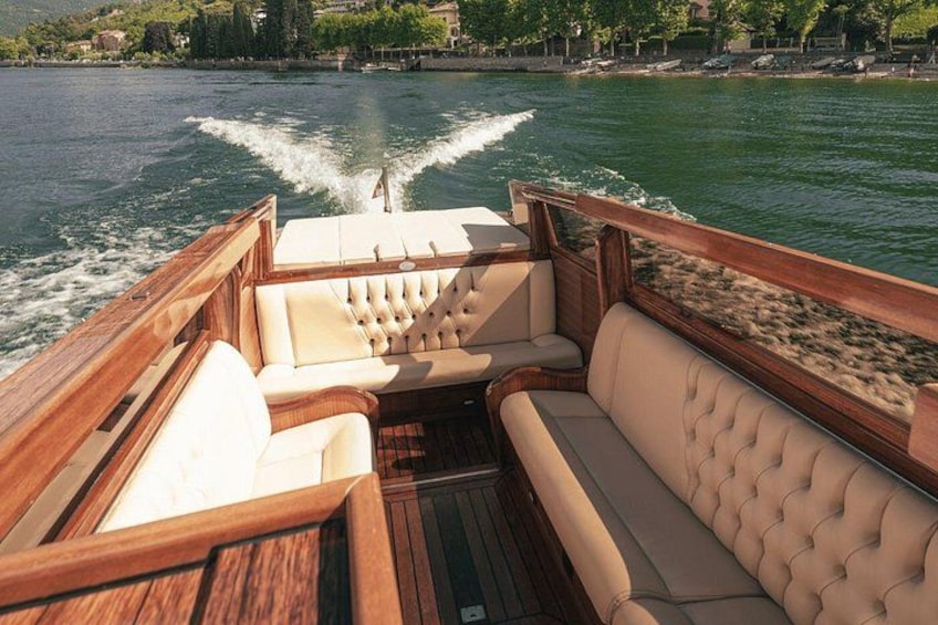 A boat's interior with wooden deck and cushioned seating. 3