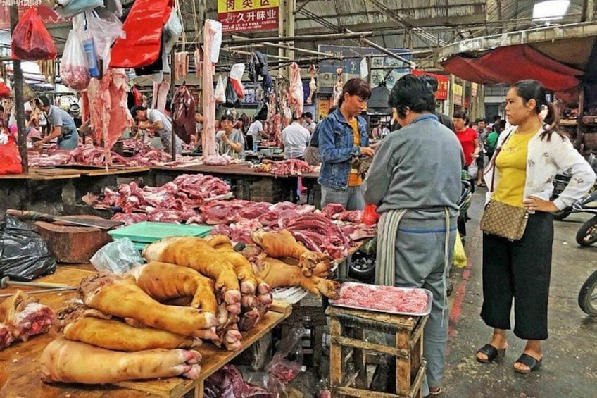 Ein belebter Markt mit verschiedenen Fleischsorten auf Tischen. 1
