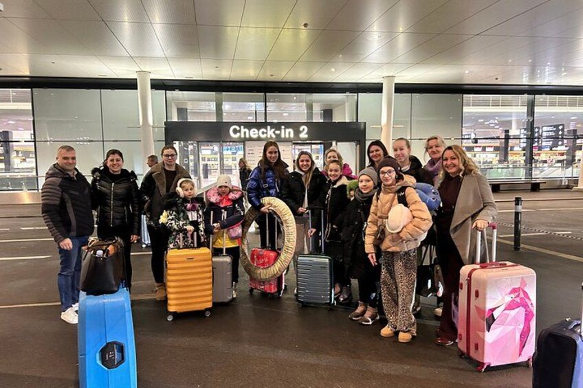 Un groupe de personnes se trouve dans la zone d’enregistrement d’un aéroport, près des bagages. 5