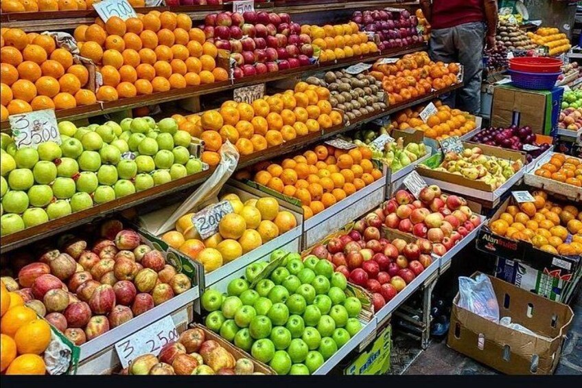 A fruit market with various fruits like apples, oranges, and bananas on display. 5