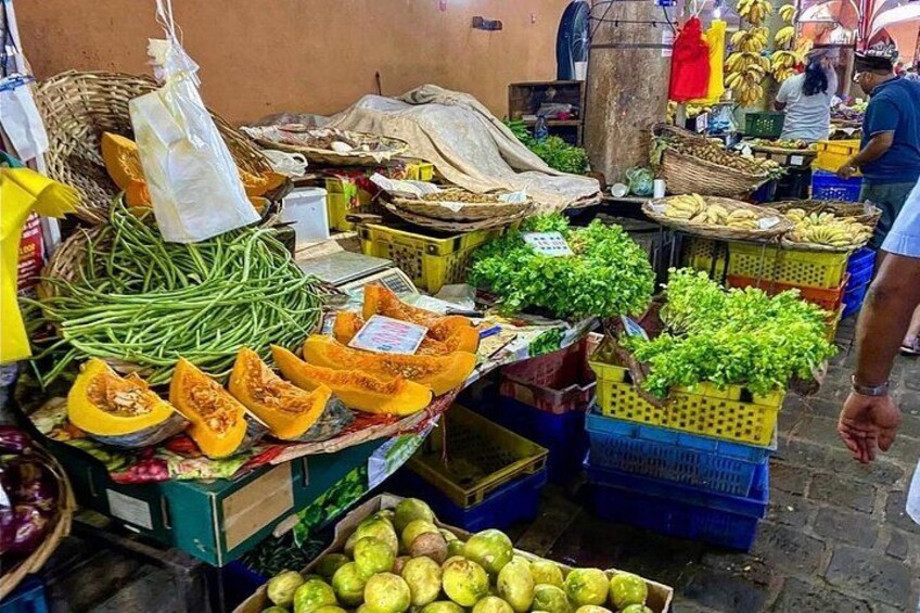 A market with various fruits and vegetables displayed in baskets and crates. 4