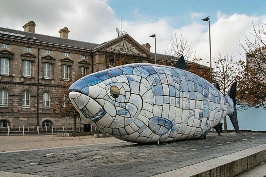 A mosaic fish sculpture on a sidewalk. 4