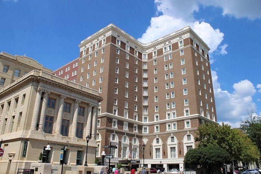 A large, historic building with classical architecture, including columns and arched windows, situated in an urban setting with clear skies. 2