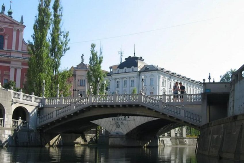 A stone bridge over a river with buildings on either side. 4