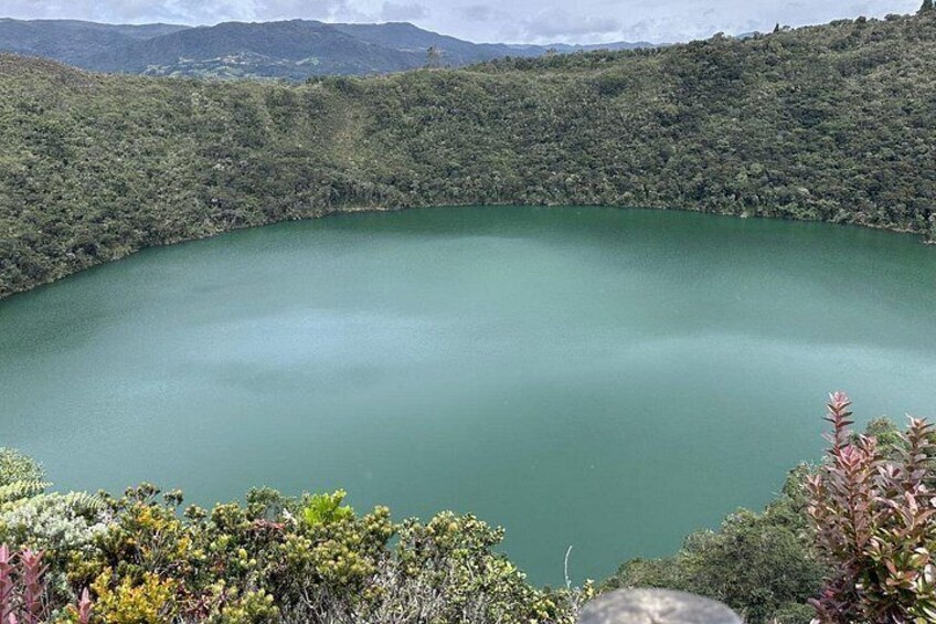 A large, circular lake surrounded by dense forest. 1