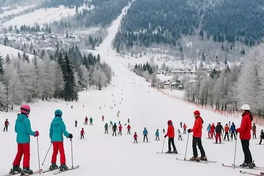 A snowy ski slope with skiers descending. 2