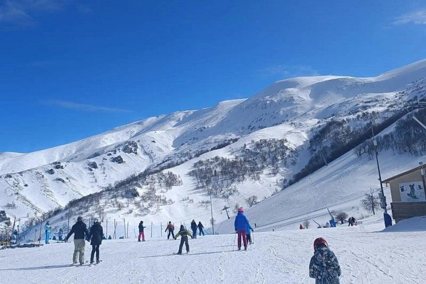 A snowy mountain landscape with skiers and snowboarders. 3