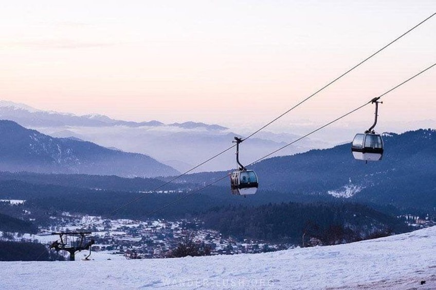 A cable car system in a mountainous area with snow-covered terrain and distant peaks. 5