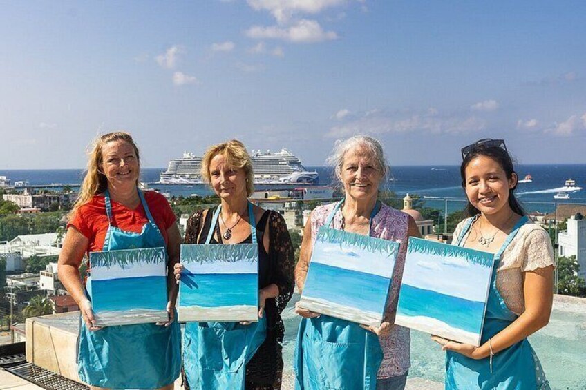 Four people holding paintings of a beach scene, with a cruise ship and cityscape in the background. 1