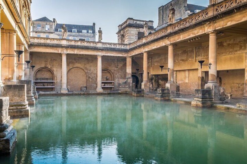A historic courtyard with a central pool, columns, and arches. 3