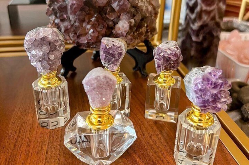 Una colección de frascos de perfume de cristal sobre una superficie de madera. 2