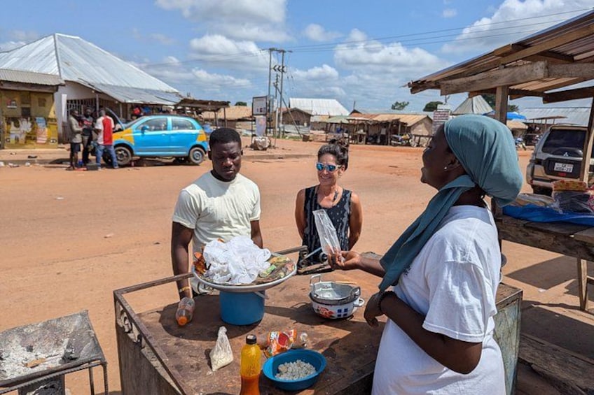 A street vendor with a cart, a woman in a white shirt, and a man in a white shirt. 3
