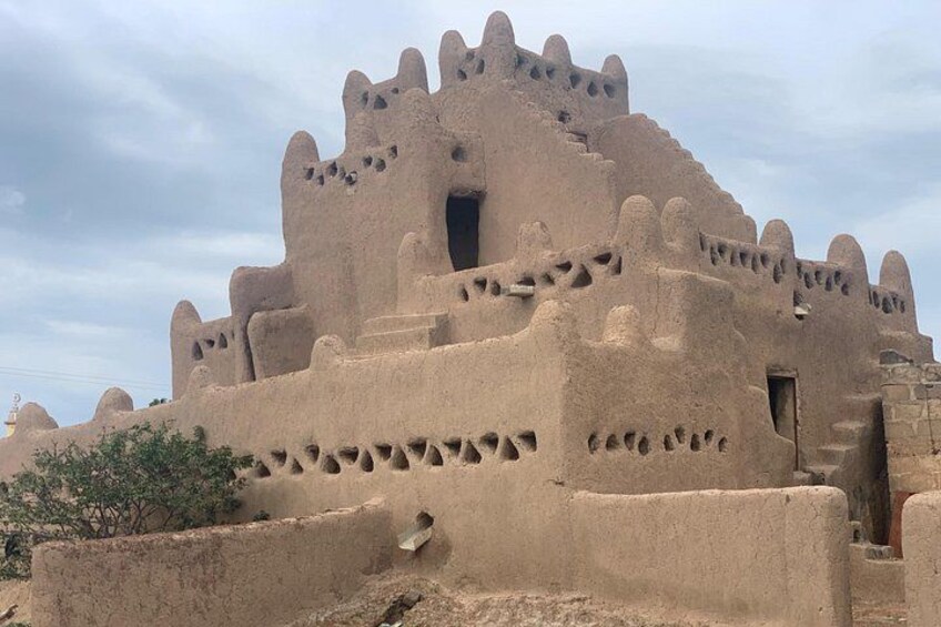 A traditional mud-brick building with a conical roof and multiple protruding towers. 5