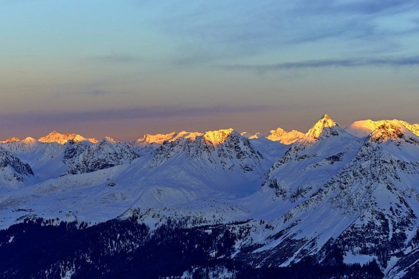 A snow-covered mountain range with peaks illuminated by sunlight. 5