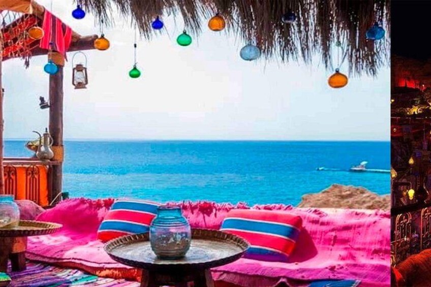 A beach setting with colorful cushions, a table with a glass vase, and a thatched roof structure. 1