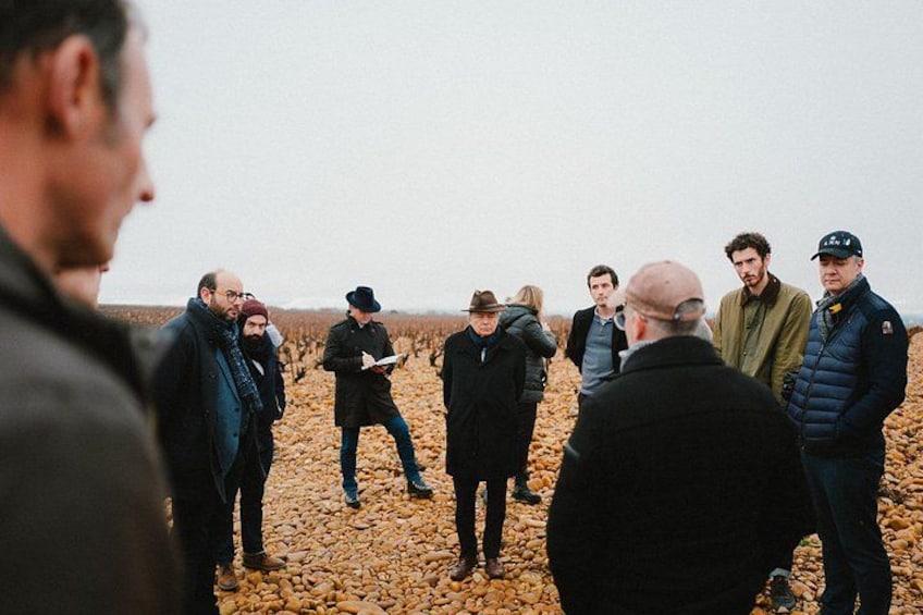 A group of people standing in a field with dry, rocky ground. 2