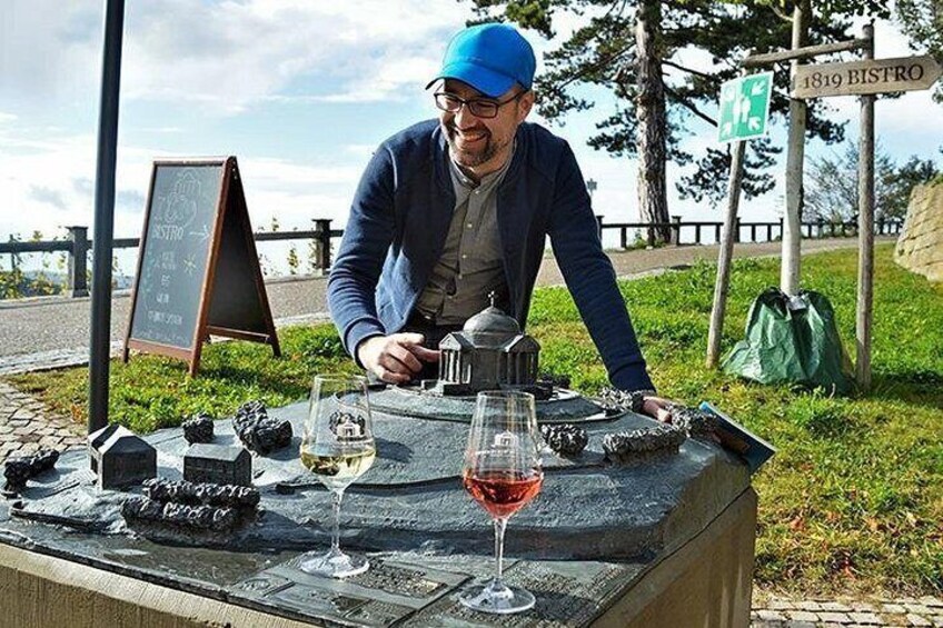 Un homme est assis à une table devant un panneau indiquant « 1819 BISTRO » et un tableau noir servant de menu. 3