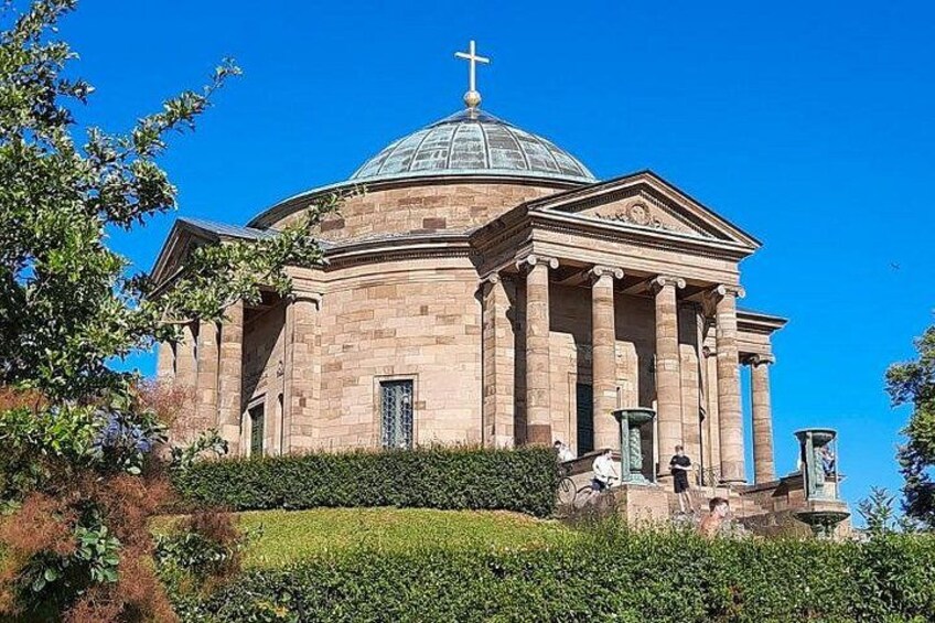 A large, historic building with a dome and columns, surrounded by greenery. 2