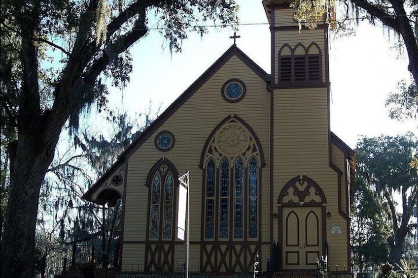 A church with a steeple, arched windows, and a clock. 3
