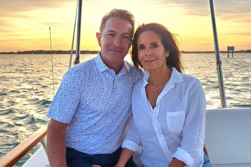 Two people on a boat with a sunset in the background. 2