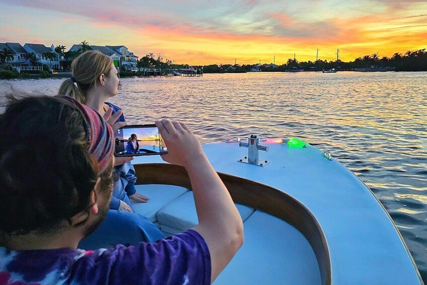 A boat on water with a sunset in the background. 4