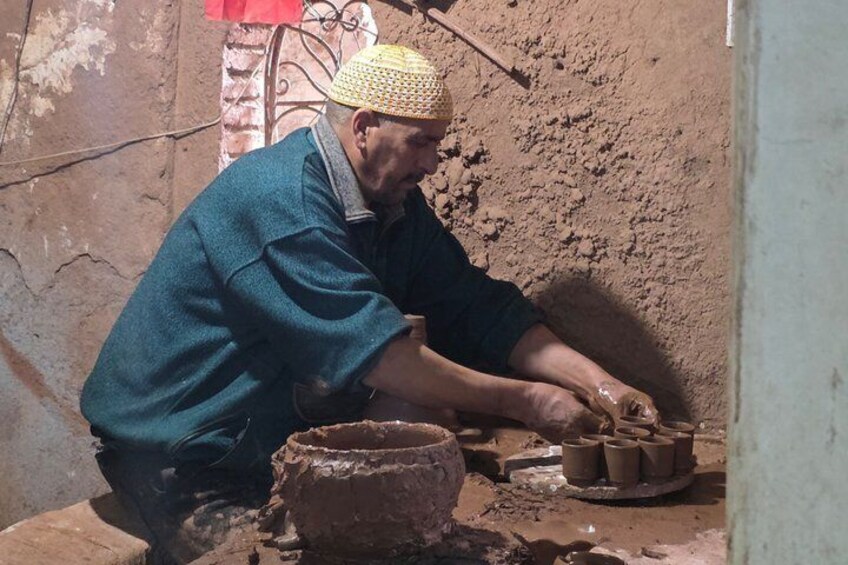 A person working with clay pots in a rustic setting. 5
