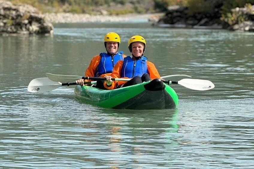 Two people kayaking on a calm river. 5