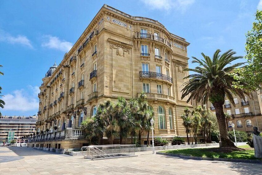A historic building with classical architecture, a paved square, and palm trees. 3