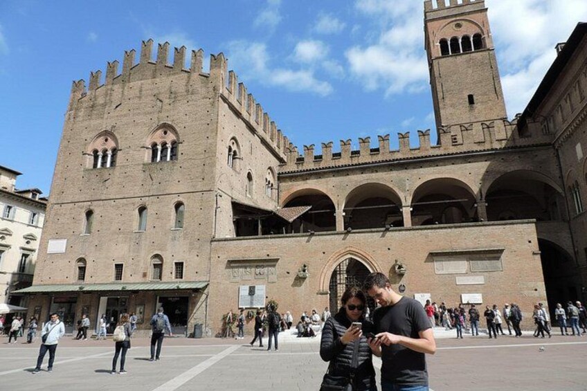 A historic building with a tower, arched windows, and a central courtyard. 3