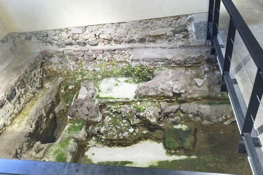 Un sitio de excavación arqueológica con capas de piedra expuestas y una baranda de metal. 3