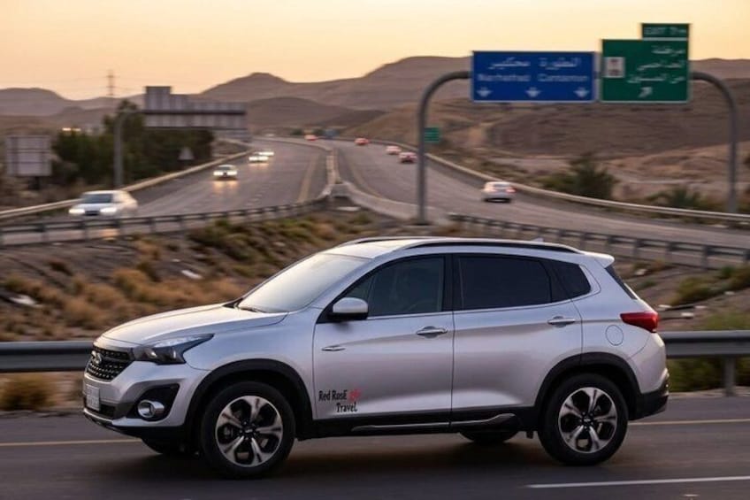 Un VUS argenté sur une autoroute, avec un paysage désertique en arrière-plan. 4