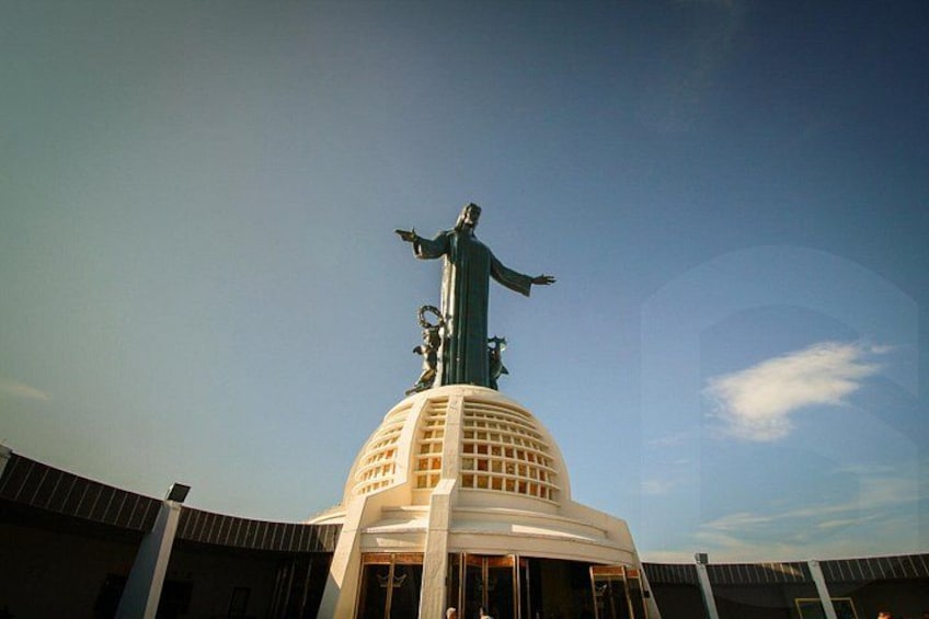 A large statue on top of a building with a dome and a clear sky in the background. 4