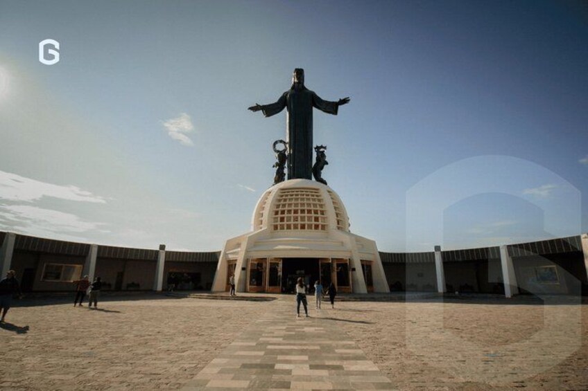 A large statue with outstretched arms, a dome-shaped base, and a surrounding plaza. 1