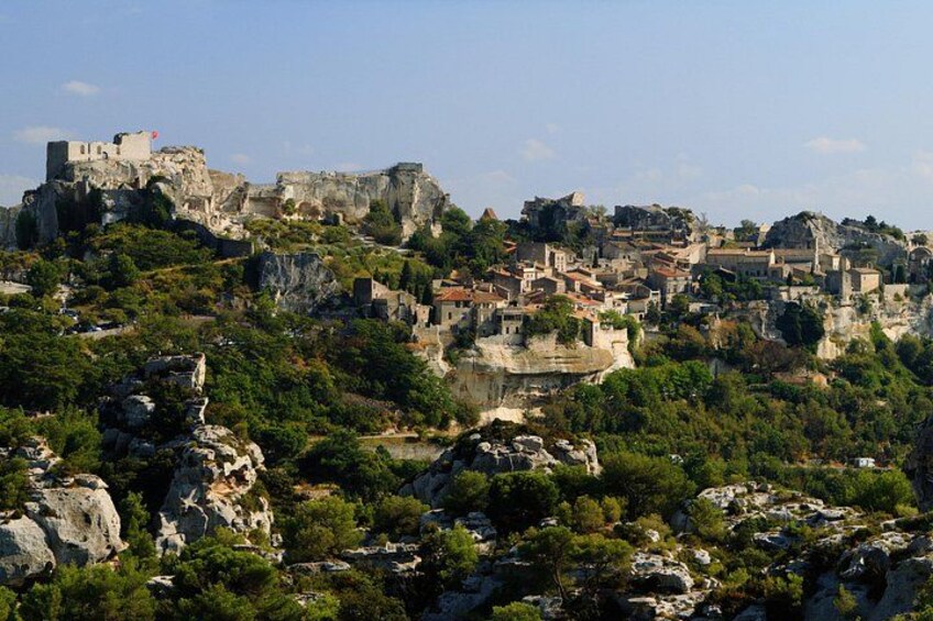 Eine Stadt, die auf felsigem Gelände liegt, mit historischen Gebäuden und einem Schloss auf einem Hügel. 1