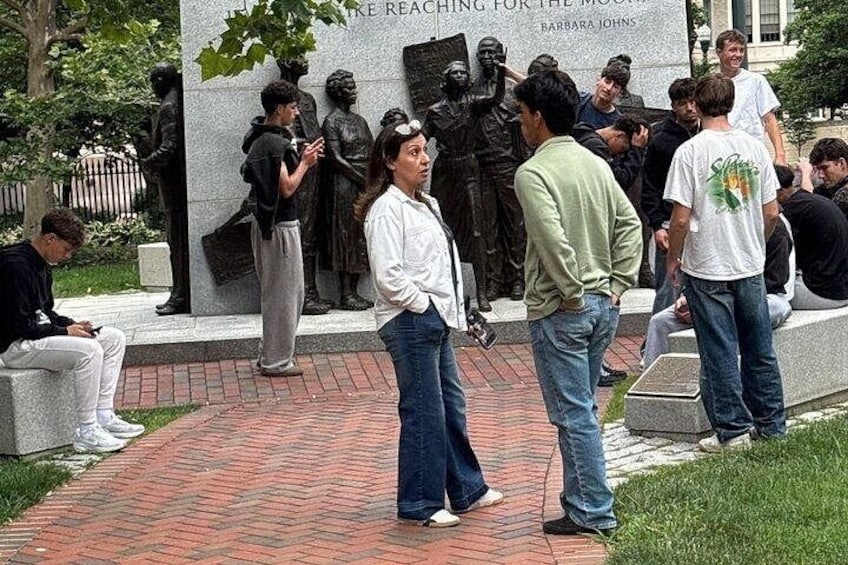A group of people standing in front of a statue with the inscription 'REACHING FOR THE MOON' and 'BARBARA JOHNS'. 2
