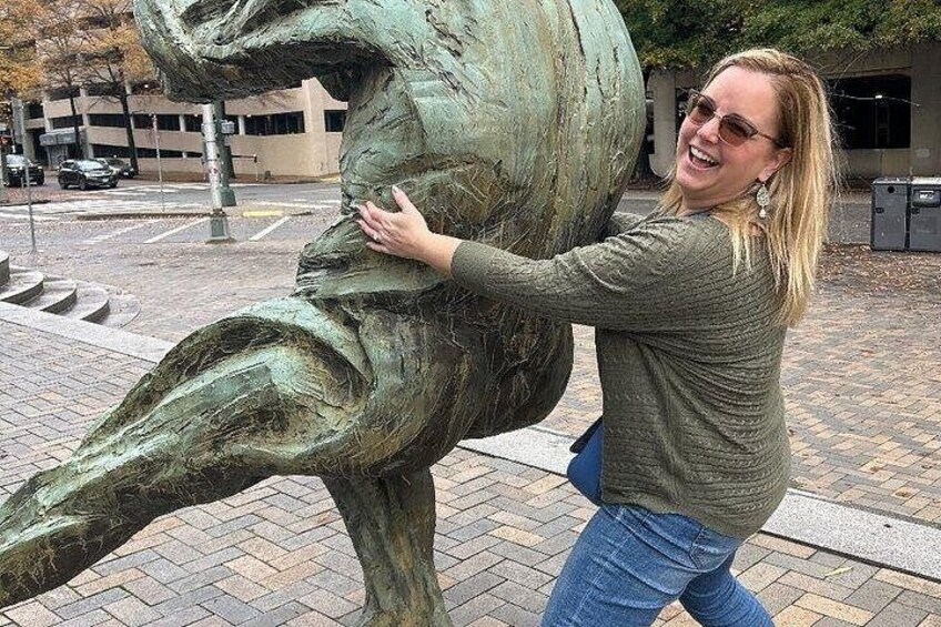 A person touching a bronze statue of a horse. 4