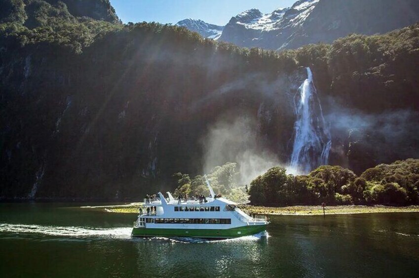 A boat on a lake with a waterfall in the background. 3