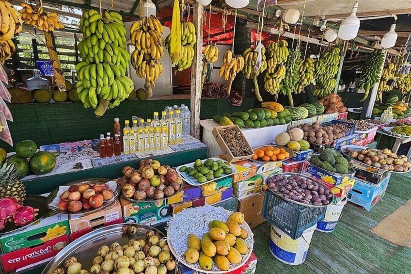 A fruit market with various fruits and vegetables on display. 2