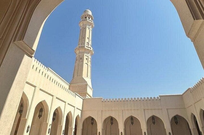 A mosque with a tall minaret and arched doorways. 3