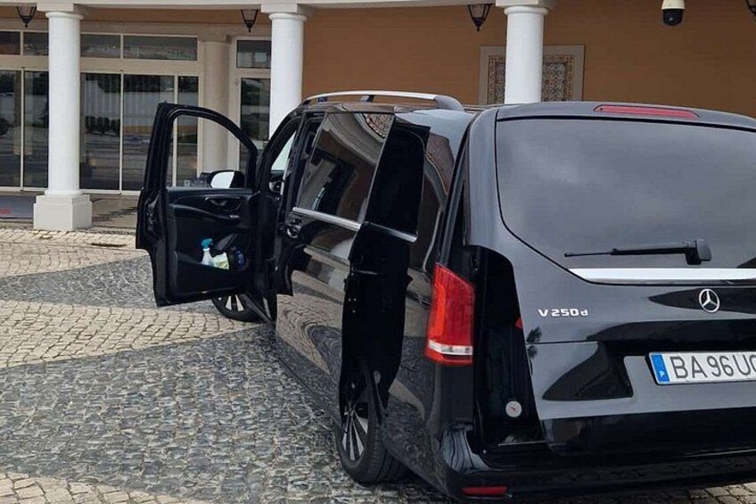 A black Mercedes-Benz V250d parked in front of a building with a cobblestone driveway. 3
